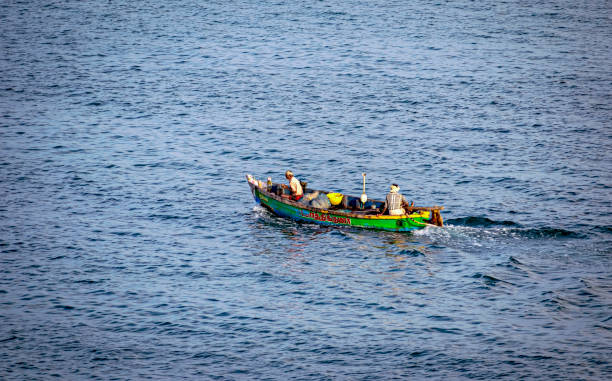 rybacy jeżdżą swoją pojedynczą, małą łodzią, aby złapać ryby w morzu. - fishing nautical vessel small men zdjęcia i obrazy z banku zdjęć