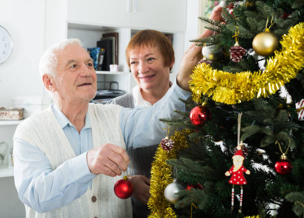 istock Elderly couple decorate firtree 1355127006