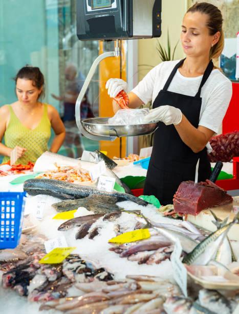 istock Female weighing raw prawns on scales 1355127157