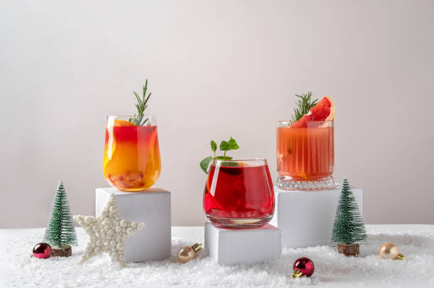 Świąteczne koktajle cytrusowe na podium. Asortyment świeżych świątecznych napojów. Ró�żowe i czerwone koktajle sangria, jingle z granatu i cytrusowa tequila smashy. – zdjęcie