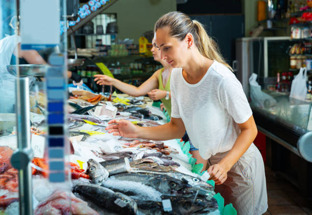 istock Female customers choosing fresh raw seafoods 1355127619