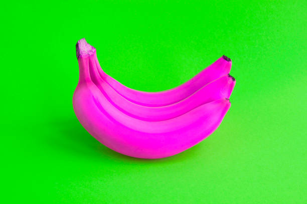 istock Close-up on pink banana on the green background. Copy space. 1355127953
