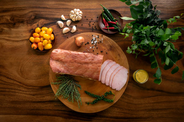 smoked pork loin ham on rustic wood table with natural ingredients arrangement smoked pork loin ham on rustic wood table with natural ingredients arrangement smoked pork stock pictures, royalty-free photos & images