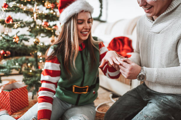 istock Female Getting Engagement Ring Put On Finger By Boyfriend While Celebrating Christmas 1355130149