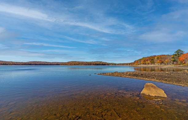 Lake Wallenpaupack in Poconos PA on a bright fall day lined with trees in vivid and beautiful foliage stock photo