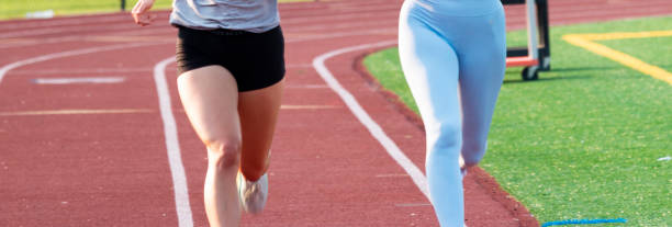 istock Legs of two women running side by side on a track 1355134565