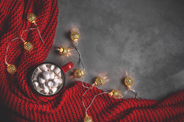 istock mug with drink marshmallow, garlands, red blanket on a gray background 1355135510