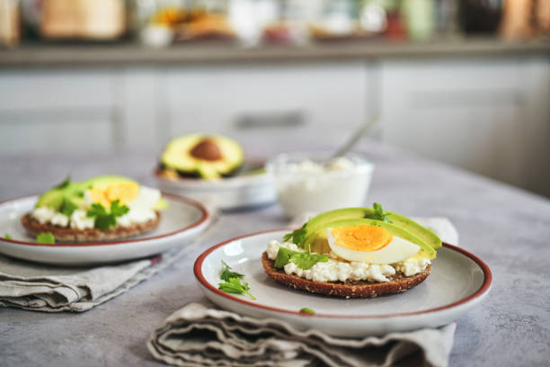 сэндвич с авокадо с коричневым хлебом, творогом и вареными яйцами - brown bread bread home interior food стоковые фото и изображения