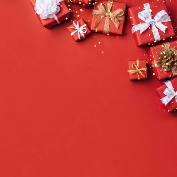 istock Gift boxes with white and brown bows on a red backdrop. 1355137137