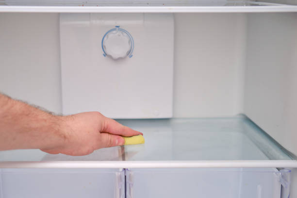 istock A man hand with a yellow sponge washes the refrigerator 1355137618
