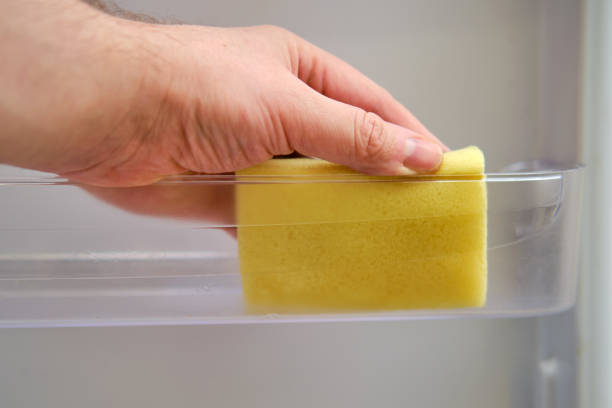 istock A man hand with a yellow sponge washes the refrigerator 1355137623
