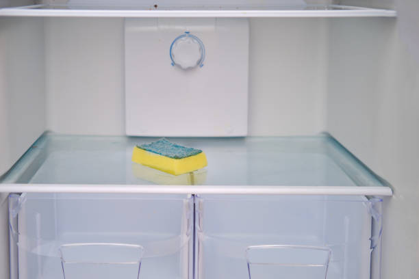 istock A man's hand with a yellow sponge washes the microwave 1355137625