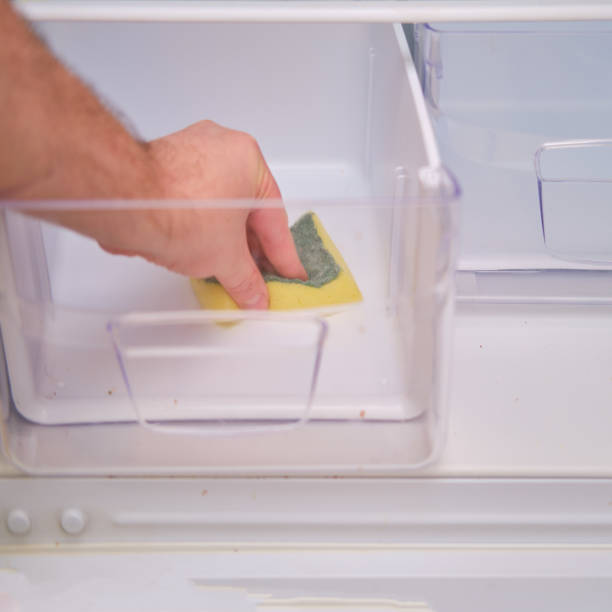 istock A man hand with a yellow sponge washes the refrigerator 1355137629