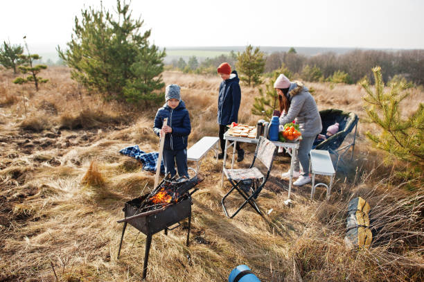 istock Family barbecuing on a deck in the pine forest. Bbq day with grill. 1355137785