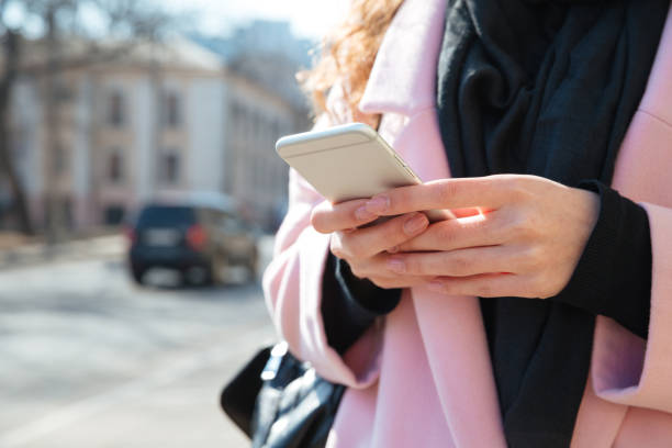 istock Cropped image of woman using smartphone 1355140378
