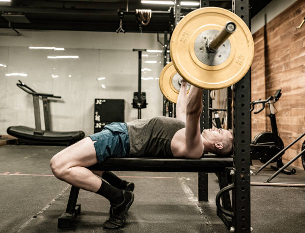 istock Young Man lifting weights in the Gym 1355140664