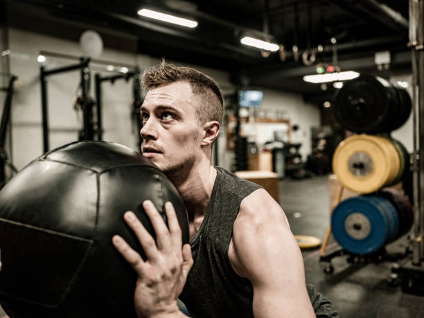 istock Man exercising with beanbag in the Gym 1355140971