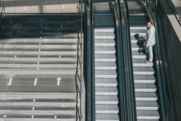 istock senior business man coming up on escalator 1355141123