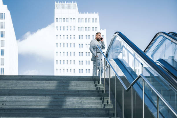 istock senior business man talking at mobile in modern city 1355141821