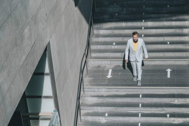 istock senior business man coming down stairs 1355141861