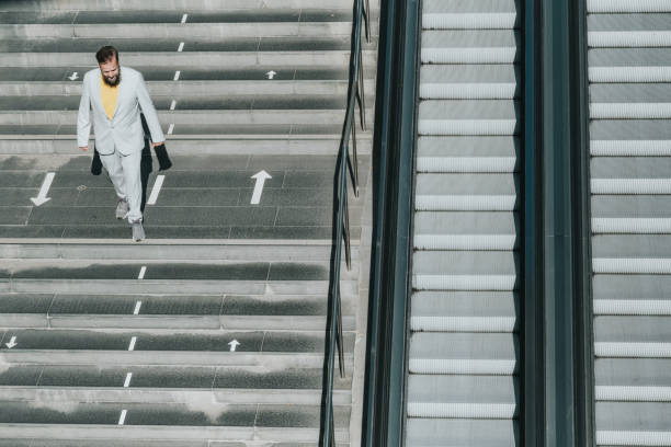 istock senior business man coming down stairs 1355142186
