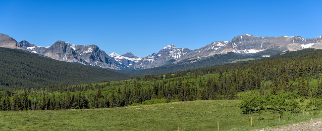 A clear sunny Spring morning view of Cut Bank Valley, surrounded by rugged high peaks of Lewis Range, as seen from Highway 89. Glacier National Park, Montana, USA.