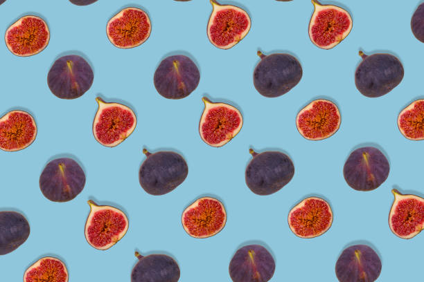 istock Pattern of fresh ripe whole and sliced figs on blue background. Creative food concept. 1355143494