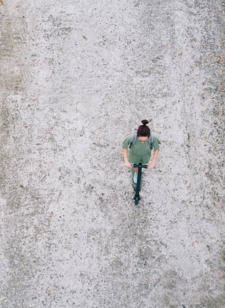 istock Young woman with a backpack rides an electric scooter. 1355146283