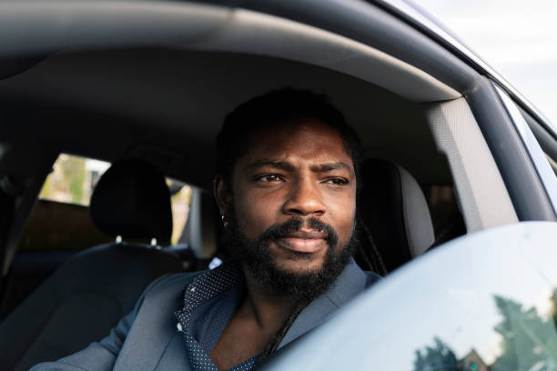 istock businessman stands inside the car while looking away 1355146476