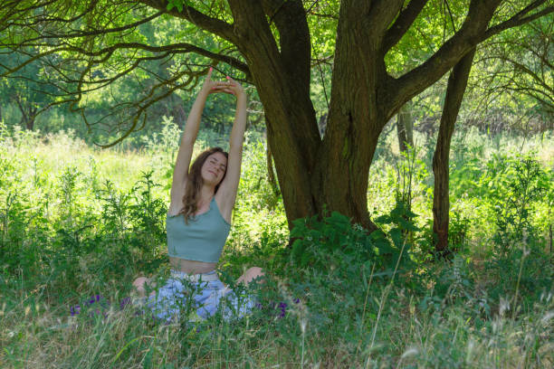 istock Woman sitting and stretching on ground under a tree 1355147725