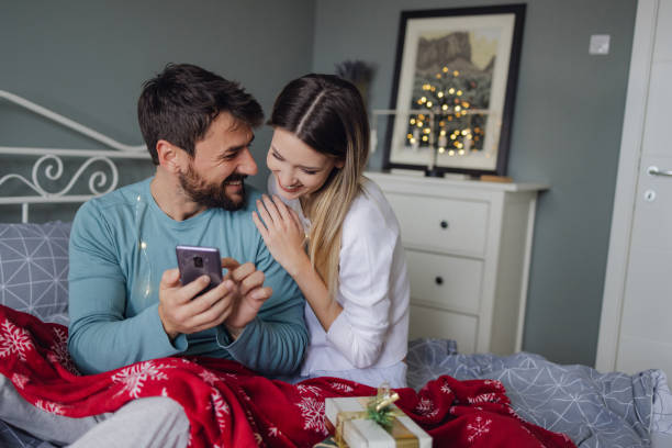 istock Cozy moments during Christmas holidays in bed using mobile phone 1355147867