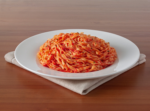 Delicious pasta servings with tomato sauce on counter top