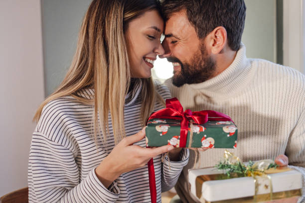 istock Excited young couple opens Christmas gifts 1355151580