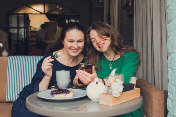 istock two women talking and drinking coffee in cafe 1355153049