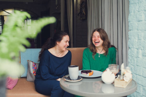 istock two women talking and drinking coffee in cafe 1355153194
