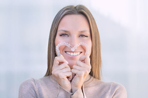 Woman with perfect smile after invisible dental aligners aligners treatment. High quality photo