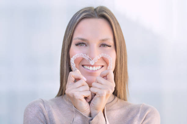 Woman with perfect smile after invisible dental aligners aligners treatment Woman with perfect smile after invisible dental aligners aligners treatment. High quality photo braces stock pictures, royalty-free photos & images