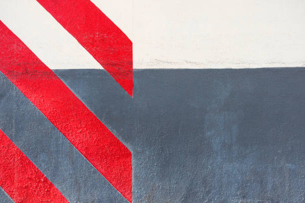 istock Abstract geometric wall texture background. Old white and gray color cement wall painted with diagonal red stripes 1355156182