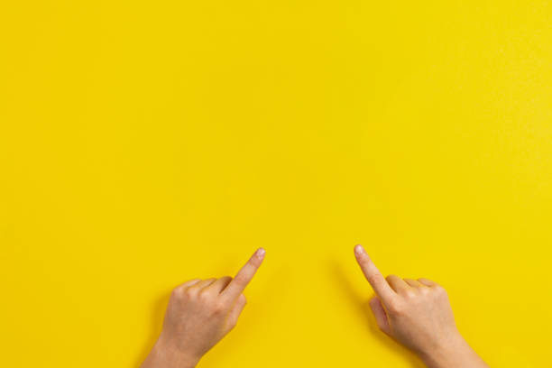 istock Kid hands pointing to something on yellow background 1355156783