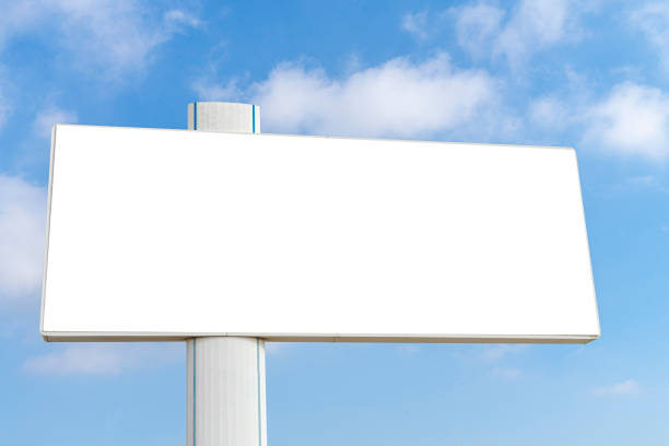 istock Mock up of big horizontal blank white billboard on blue sky with white clouds background 1355156836