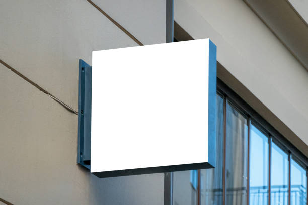 istock Mock up. Blank white rectangular shape signboard on the wall outdoors. Signage of shop, store, cafe, restaurant 1355156932