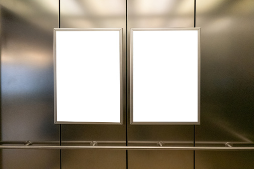 Maqueta. Dos marcos verticales de plantilla de medios de póster colgados en la pared en el ascensor del ascensor photo