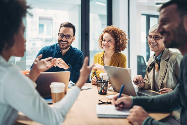 geschäftsleute sitzen am tisch und reden - business meeting teamwork office happiness stock-fotos und bilder