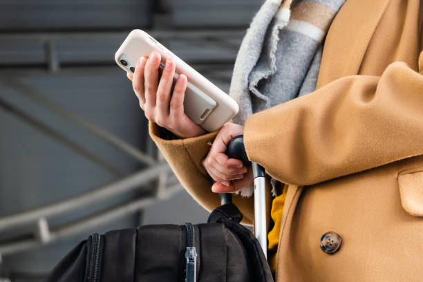 istock Passenger does flight check-in by phone in airport hallway 1355159552