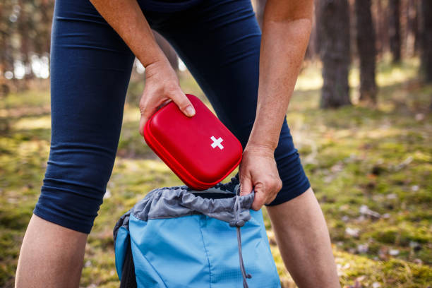 istock Woman taking out first aid kit from backpack 1355161574