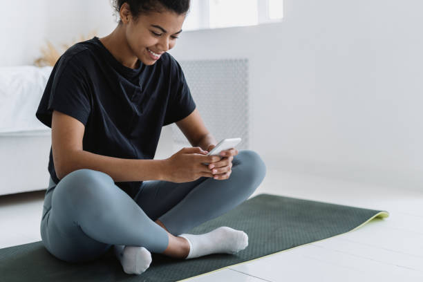 istock African american girl using smartphone while she resting after sport training 1355162111