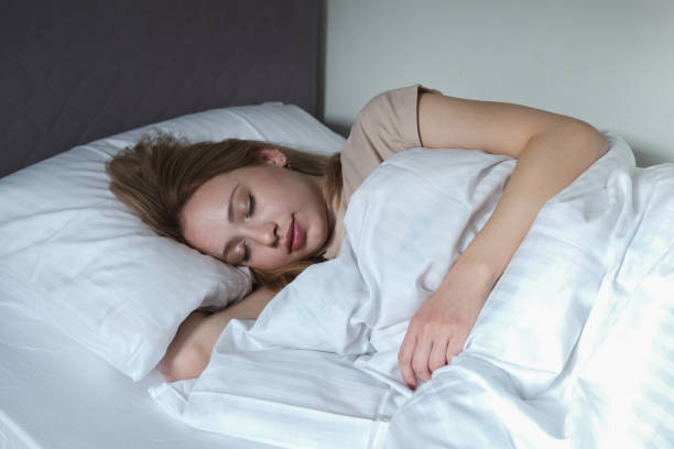 istock woman falling asleep in her white covered bed 1355162265