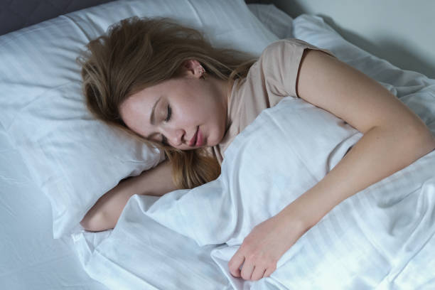 istock woman falling asleep in her white covered bed 1355162270