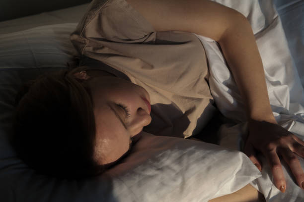 istock woman falling asleep in her white covered bed 1355162554