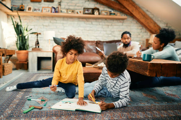 istock Creative black brother and sister drawing while relaxing on the floor at home. 1355162921
